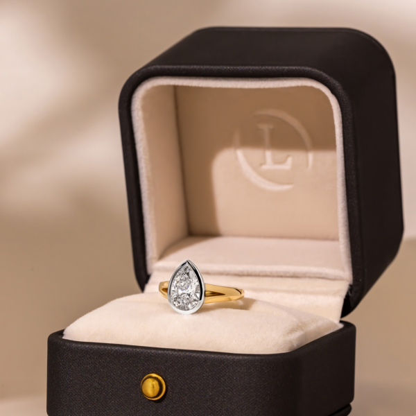 pear shaped diamond with a bezel setting and a split band